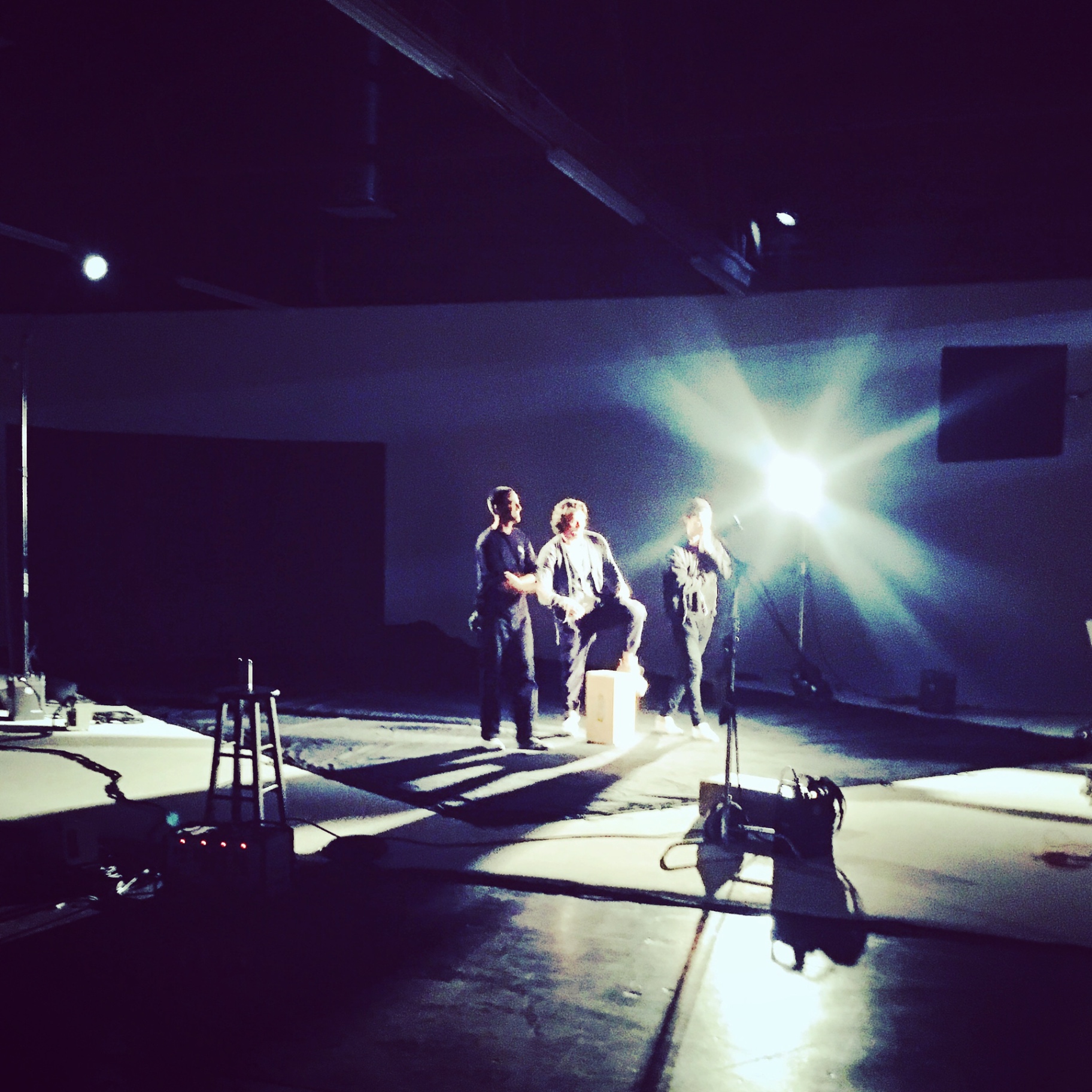 Mentor directing performers on a lit soundstage