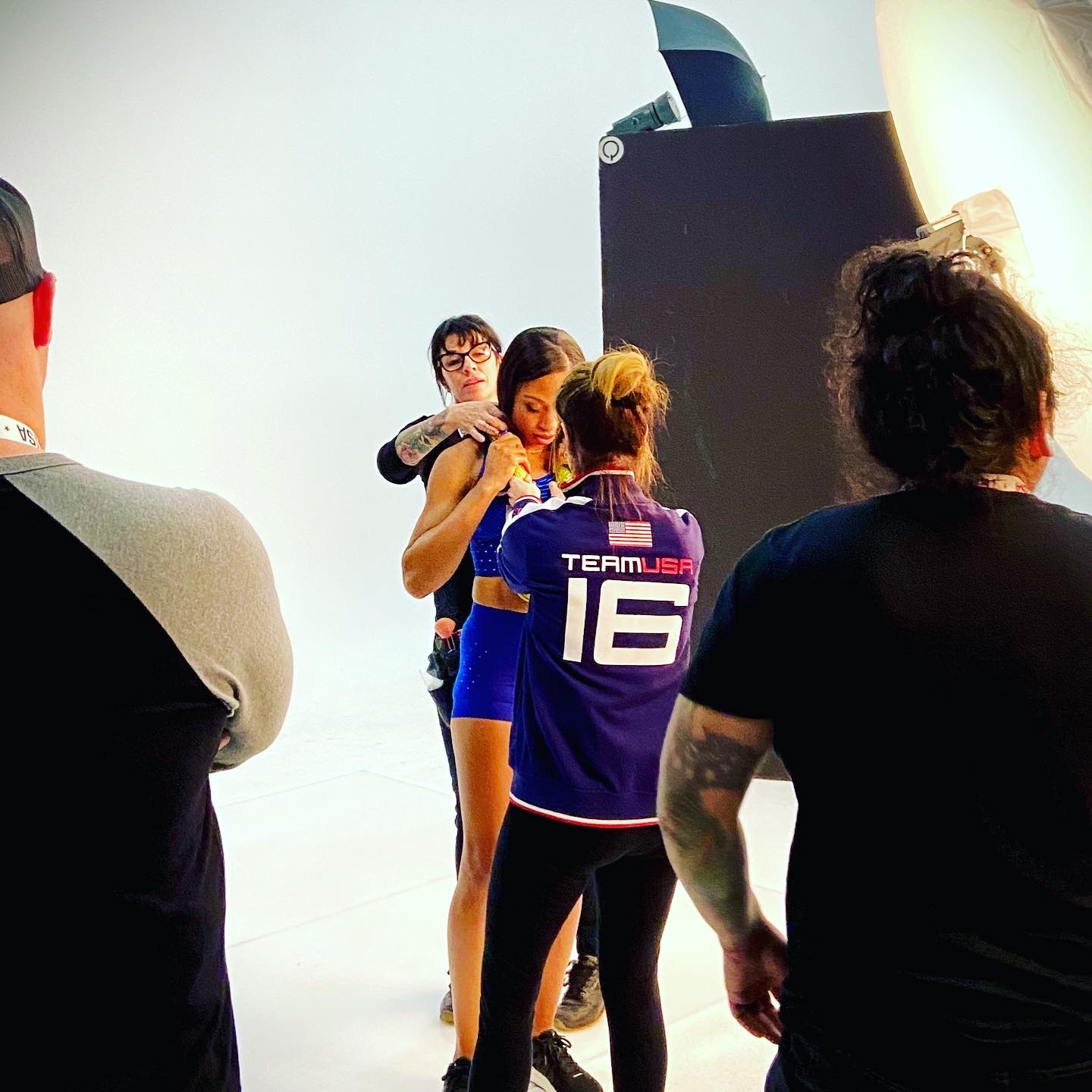 Crew on a photo set adjusting wardrobe under studio lighting