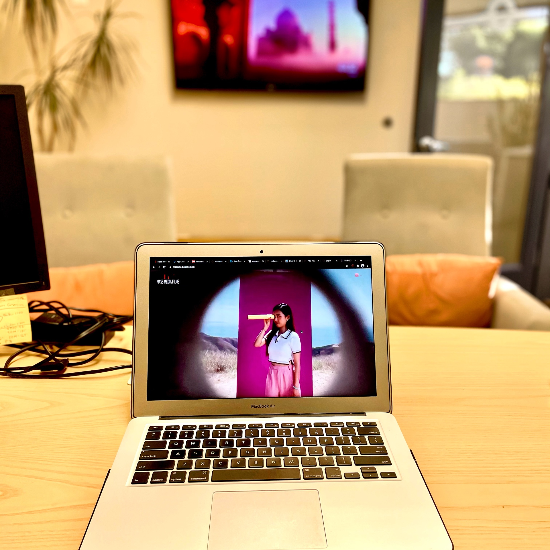Laptop showing Mass Media Films website in a studio lounge
